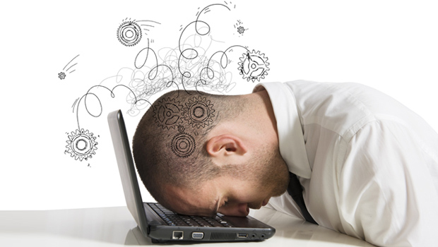Man resting head on keyboard in despair over pension advice